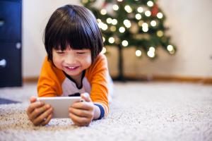 Mixed race boy playing with smart phone in living room